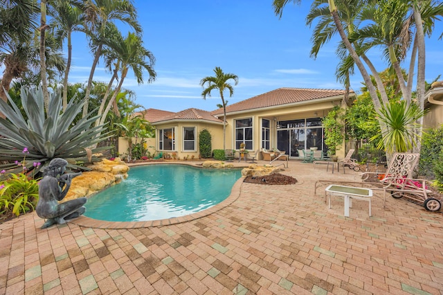 outdoor pool featuring a patio area and fence