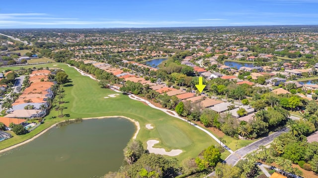 drone / aerial view with view of golf course, a water view, and a residential view