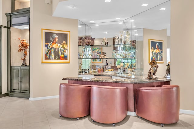 bar with light tile patterned floors, recessed lighting, indoor wet bar, and baseboards