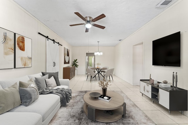 living area featuring visible vents, ornamental molding, a barn door, light tile patterned flooring, and ceiling fan