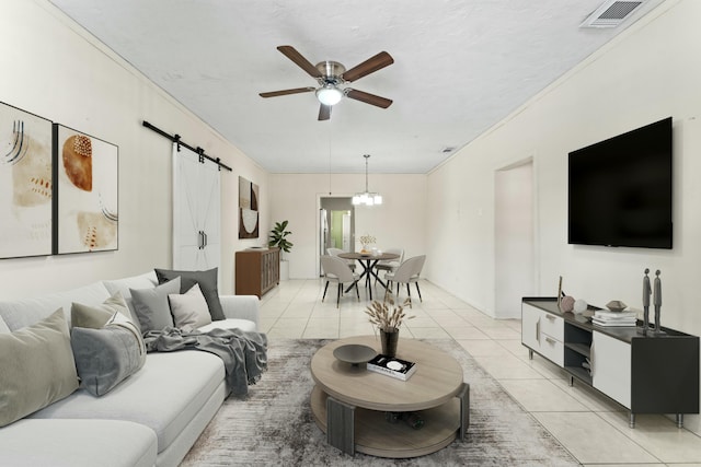 living area featuring a barn door, light tile patterned floors, visible vents, and ceiling fan