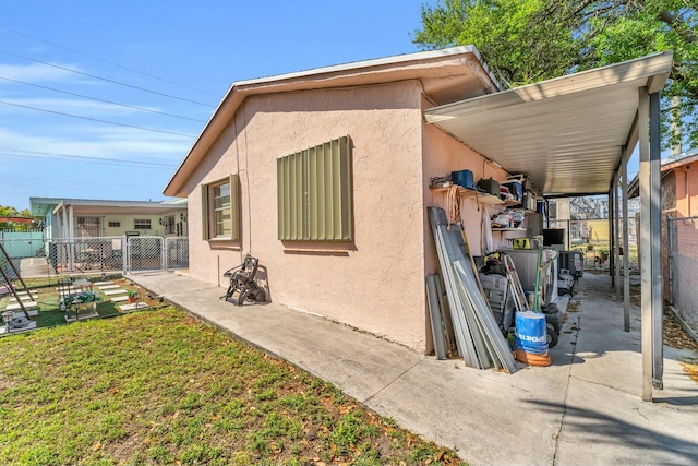 view of side of home featuring stucco siding, a yard, and fence