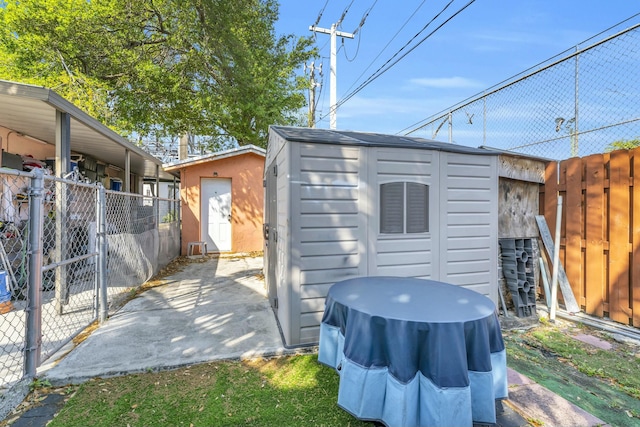 view of shed featuring a gate and fence