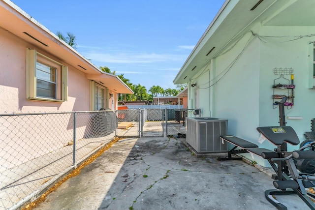 view of patio with a gate, central AC unit, and fence