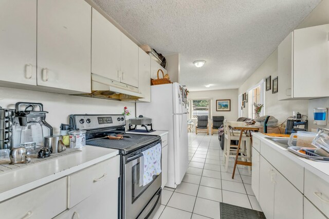 kitchen with light tile patterned floors, electric range, light countertops, under cabinet range hood, and a textured ceiling