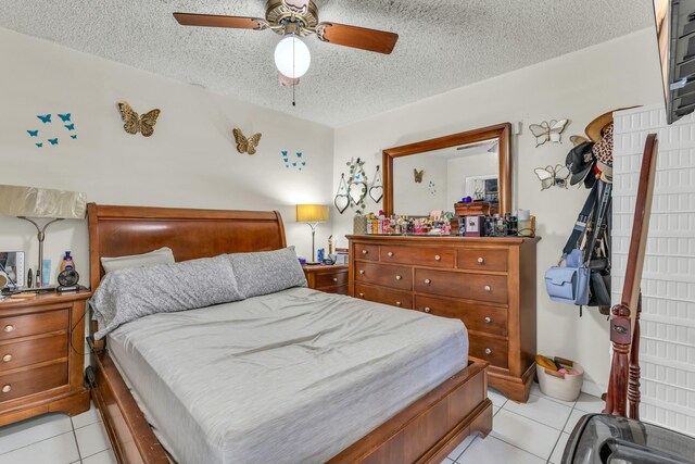 bedroom with light tile patterned floors, a textured ceiling, and a ceiling fan