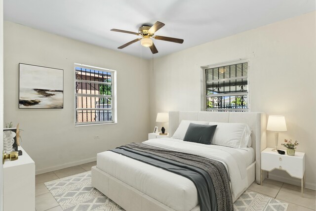 bedroom with light tile patterned floors, baseboards, and ceiling fan