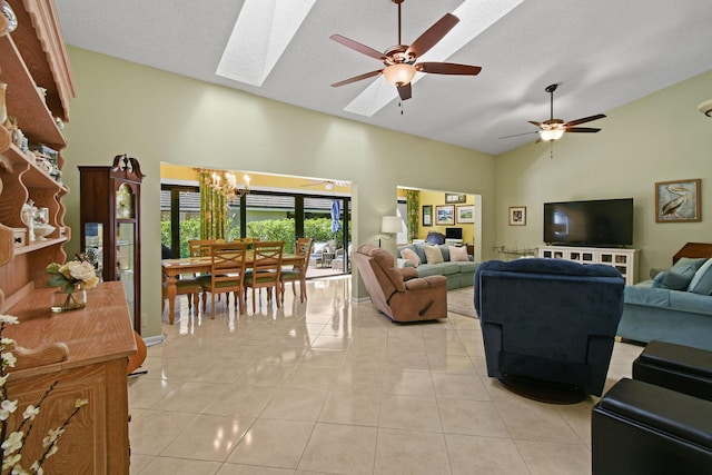 living room with a skylight, ceiling fan with notable chandelier, high vaulted ceiling, and light tile patterned flooring