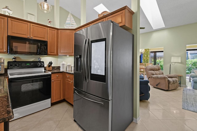 kitchen with black microwave, light tile patterned floors, a skylight, electric stove, and stainless steel fridge with ice dispenser