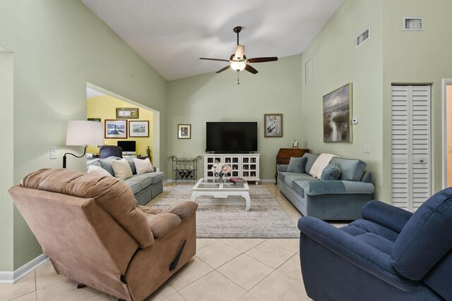 living area with light tile patterned floors, visible vents, ceiling fan, vaulted ceiling, and baseboards