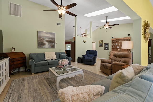 living area with a skylight, ceiling fan, light tile patterned floors, and visible vents