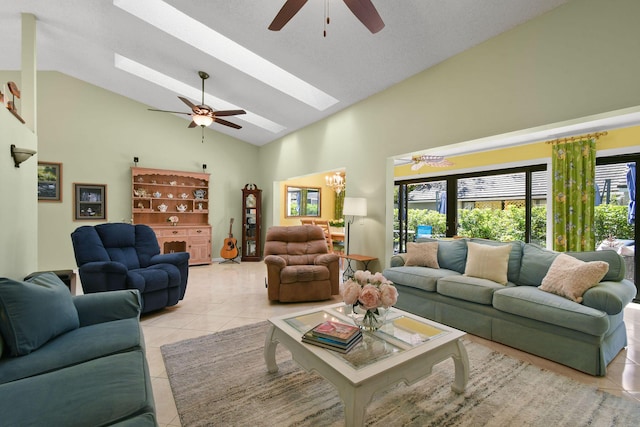 living room with light tile patterned floors, high vaulted ceiling, ceiling fan with notable chandelier, and a skylight