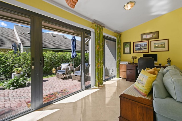 doorway to outside with lofted ceiling and tile patterned floors