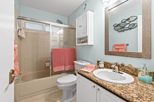 full bathroom featuring toilet, tile patterned flooring, bath / shower combo with glass door, and vanity