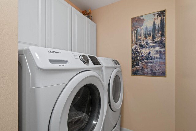 washroom featuring cabinet space and separate washer and dryer