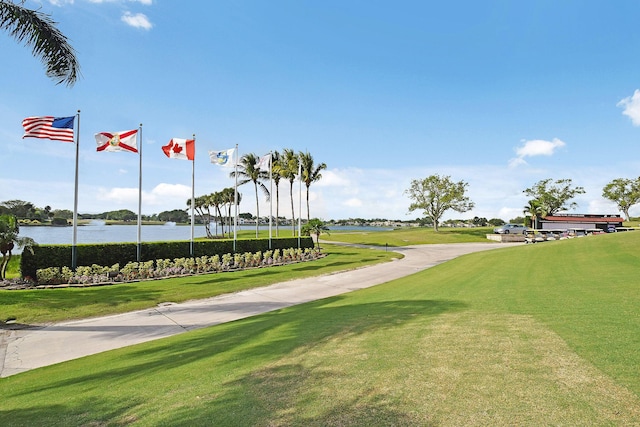 surrounding community with a lawn and a water view