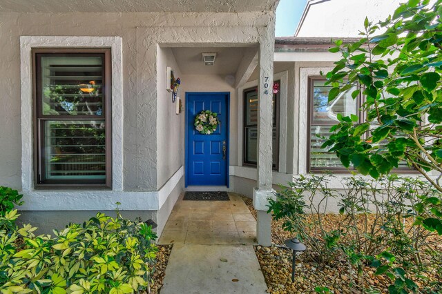 entrance to property featuring stucco siding