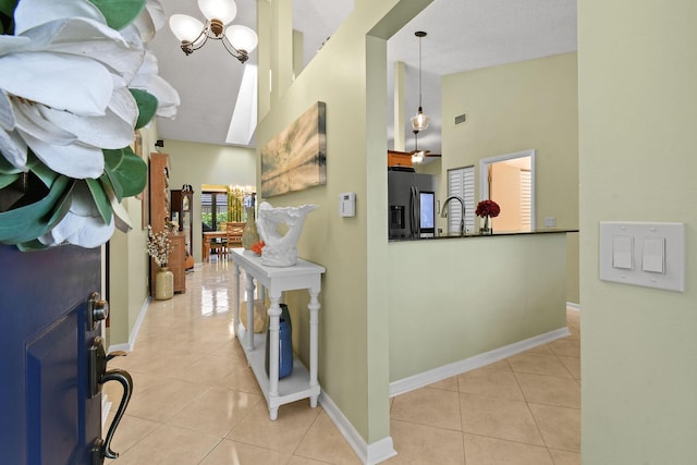 entrance foyer featuring a notable chandelier, baseboards, and light tile patterned floors