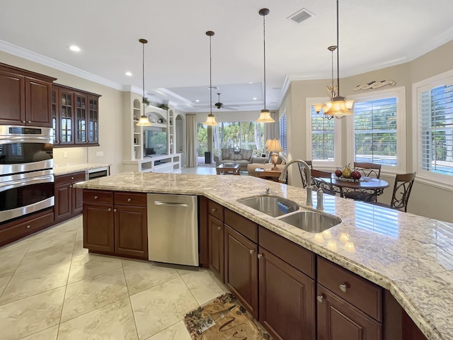 kitchen with double oven, visible vents, a sink, and crown molding