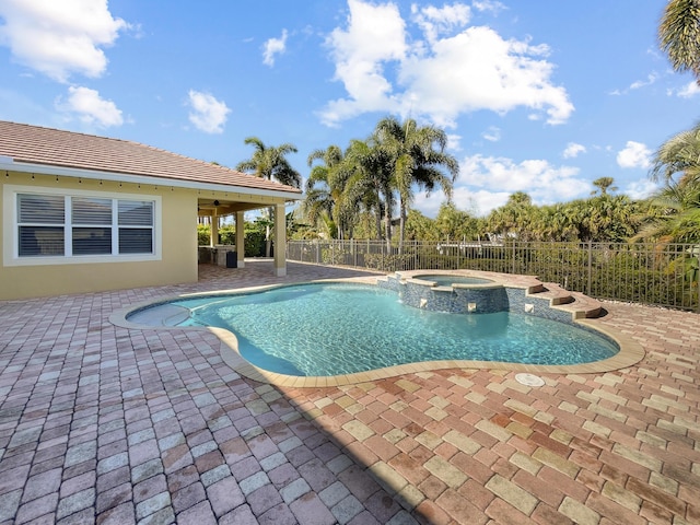 view of pool featuring a pool with connected hot tub, fence, a ceiling fan, and a patio