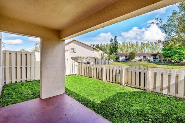 view of yard featuring a patio area, a fenced backyard, and a residential view