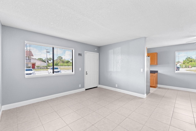 unfurnished room featuring a textured ceiling and baseboards