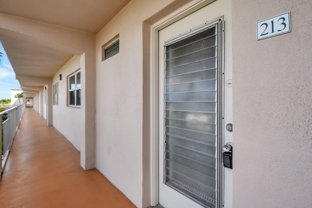 property entrance with a balcony and stucco siding