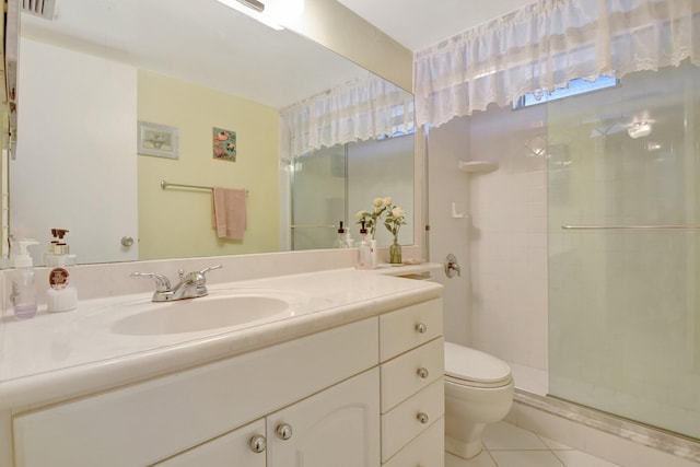 bathroom with toilet, a shower stall, tile patterned flooring, and vanity