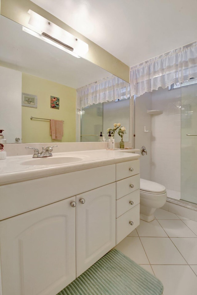 bathroom with toilet, a shower stall, vanity, and tile patterned floors