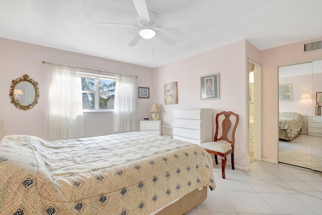 bedroom with light tile patterned floors, visible vents, baseboards, a ceiling fan, and ensuite bath