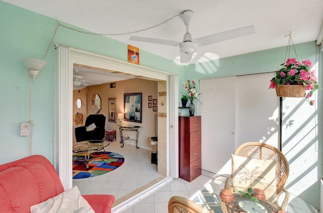 dining area with a ceiling fan and light tile patterned floors