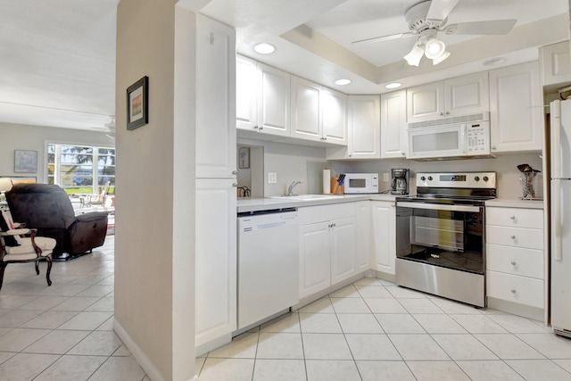 kitchen with white appliances, light tile patterned floors, light countertops, and a ceiling fan