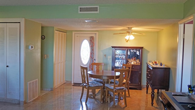 dining room featuring visible vents, ceiling fan, and a textured ceiling