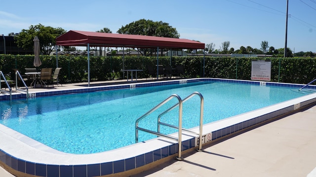 pool featuring fence and a patio