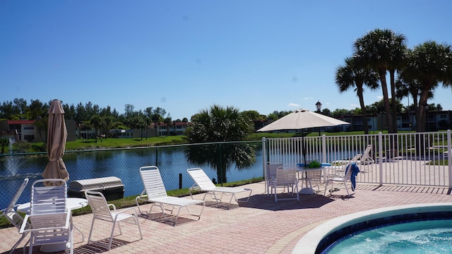 view of swimming pool with a water view and a patio area