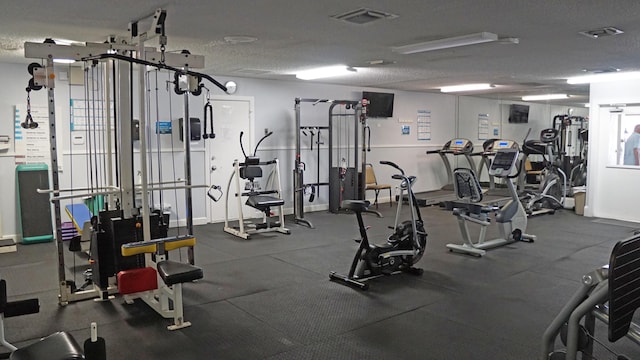 exercise room with visible vents and a textured ceiling