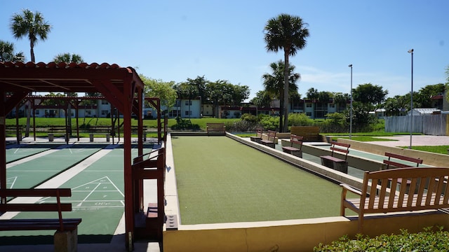 view of community featuring fence and shuffleboard