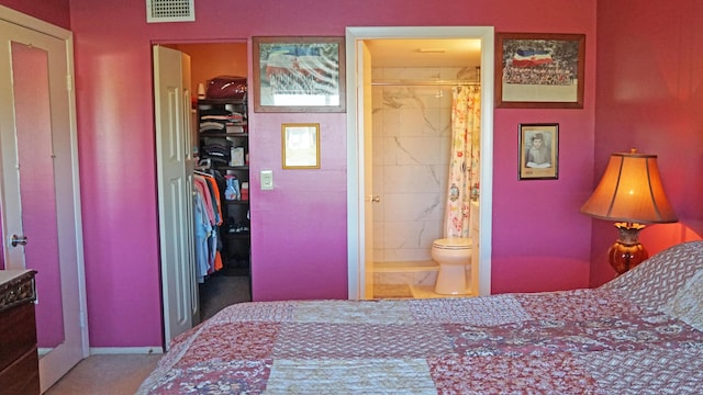 bedroom featuring a closet, a walk in closet, visible vents, and connected bathroom