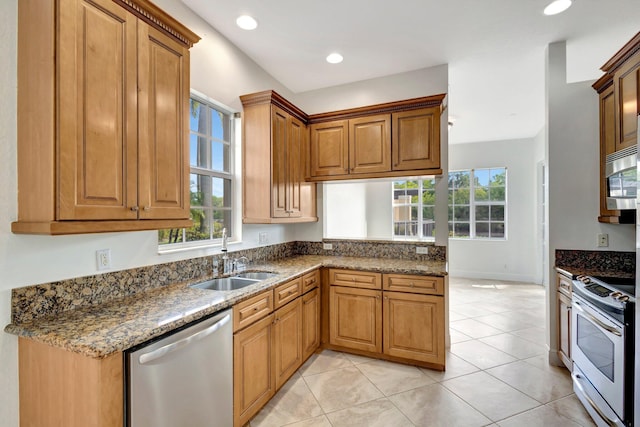 kitchen with plenty of natural light, dark stone counters, and stainless steel appliances