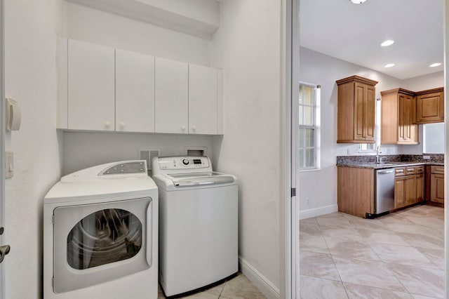 clothes washing area with cabinet space, baseboards, washing machine and dryer, a sink, and recessed lighting