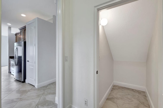 hall with lofted ceiling, recessed lighting, and baseboards