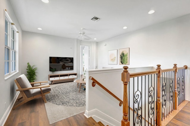 interior space with recessed lighting, visible vents, wood finished floors, and an upstairs landing