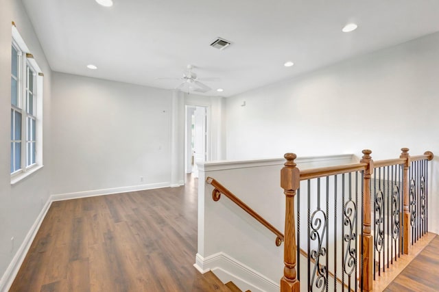 corridor featuring recessed lighting, visible vents, an upstairs landing, and wood finished floors