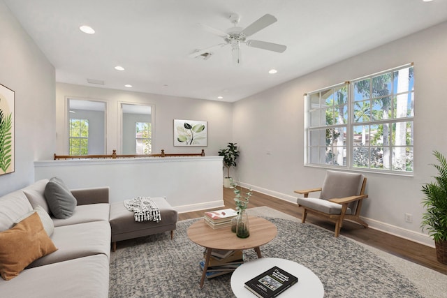 living room with recessed lighting, visible vents, baseboards, and wood finished floors