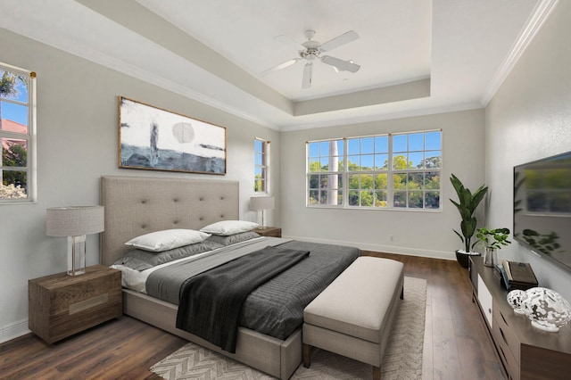 bedroom featuring ceiling fan, dark wood-type flooring, baseboards, a raised ceiling, and crown molding