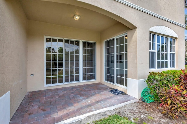 property entrance featuring a patio and stucco siding