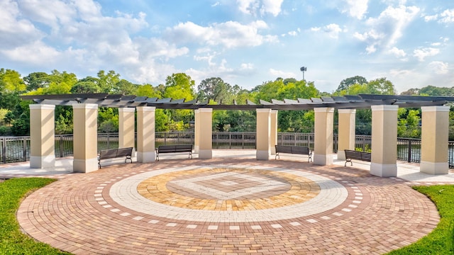 view of property's community with fence, a pergola, and a patio