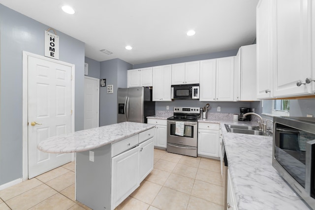 kitchen featuring stainless steel appliances, a center island, a sink, and light tile patterned floors