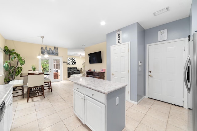 kitchen with light tile patterned floors, appliances with stainless steel finishes, visible vents, and white cabinets
