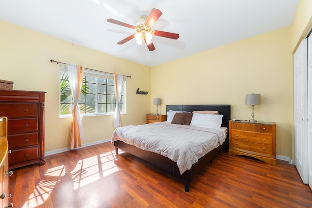 bedroom featuring a closet, ceiling fan, baseboards, and wood finished floors